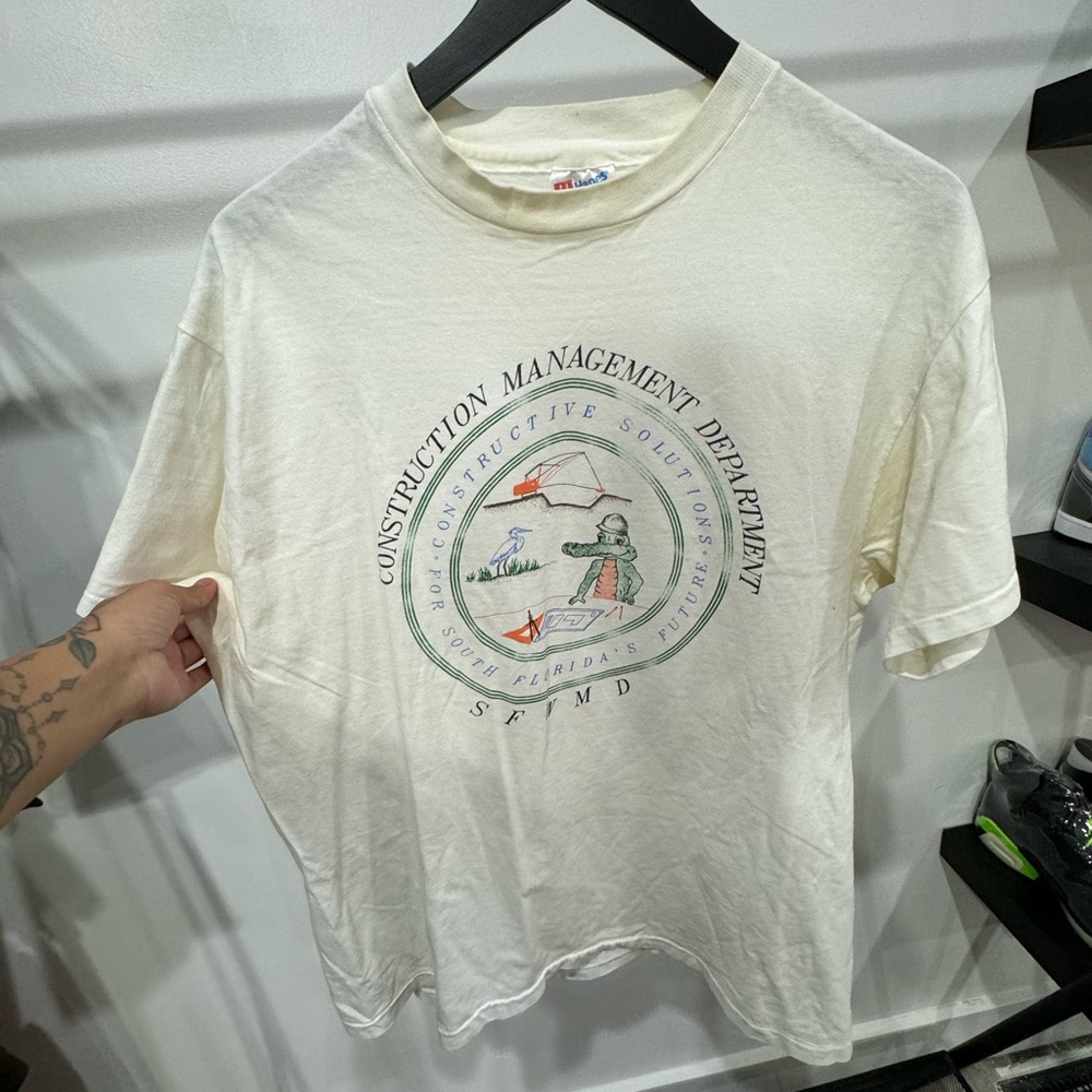 White and green Construction Management Department tee